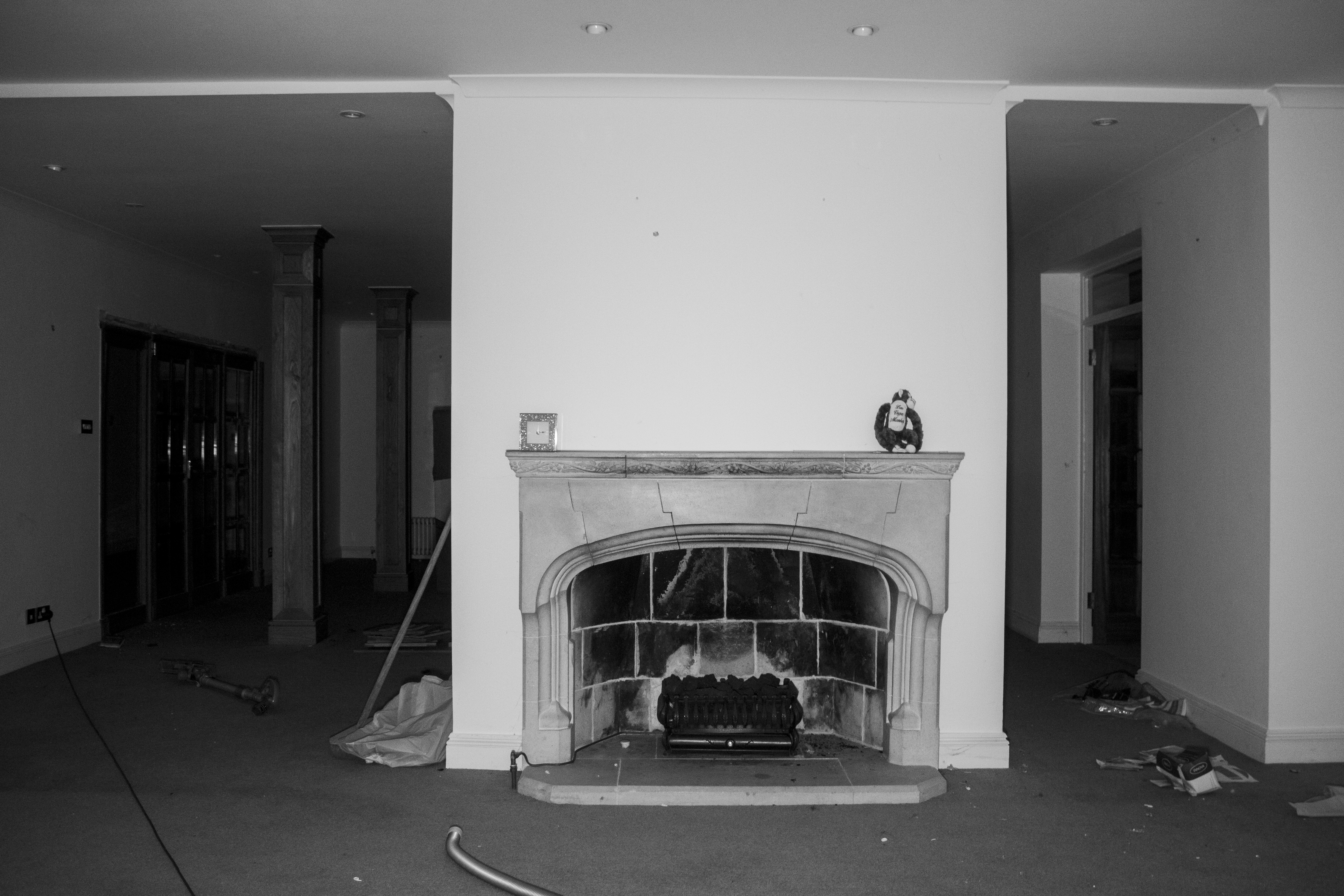 Stone fireplace and debris-strewn floor