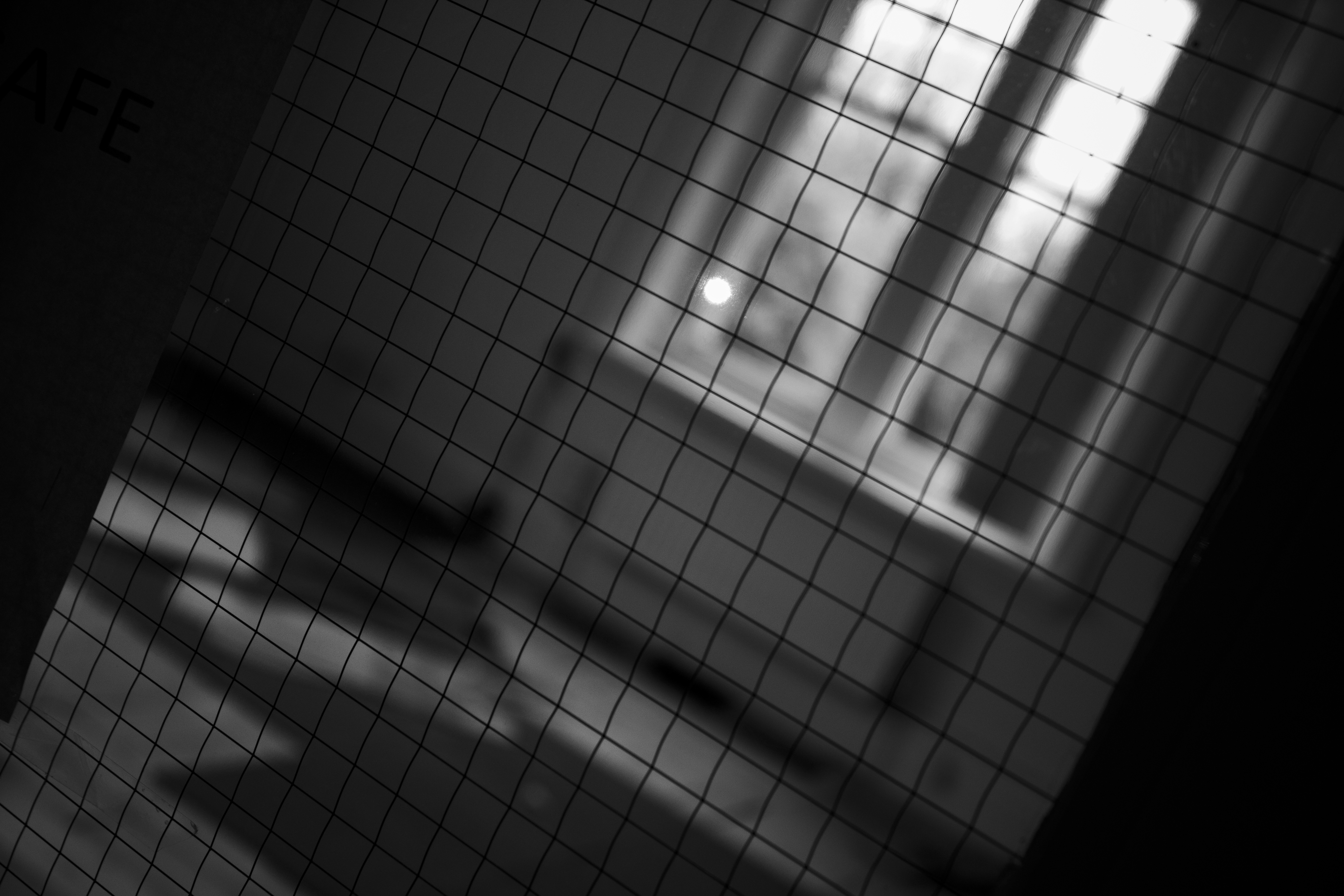 Tiled noticeboard behind shattered glass